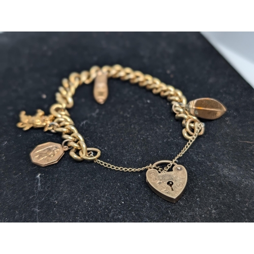 586 - 9Ct Gold Charm Bracelet with 4 Charms (all Hallmarked) with Heart Clasp. Weighing 26.07g.