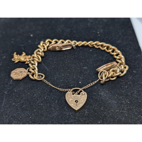 586 - 9Ct Gold Charm Bracelet with 4 Charms (all Hallmarked) with Heart Clasp. Weighing 26.07g.