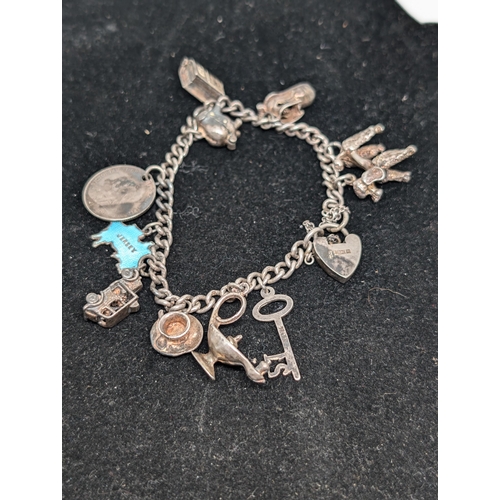 593 - Vintage Hallmarked Sterling Silver Charm Bracelet with 10 Charms attached. Weighing 37.5g