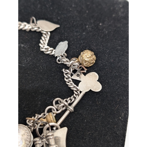 594 - Vintage Hallmarked Sterling Silver Charm Bracelet with 10 Charms attached. Weighing 57.34g