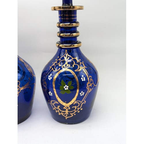 69 - Pair Attratcive Bohemian Blue Glass Decanters With Gilt Foliate and Stoppers. One Stopper Has Damage... 