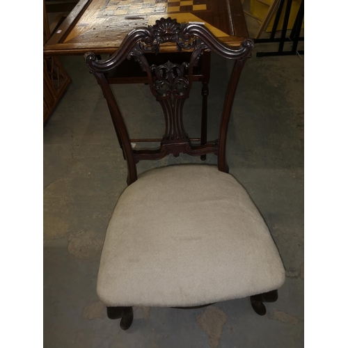 618 - Nursing chair with intricate carved wooden back.