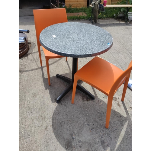 91 - round table with two orange outdoor chairs