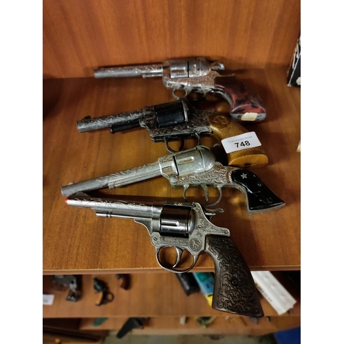 748 - Collection of four vintage cap gun six shooters including lone star peacemaker and a frontier ace