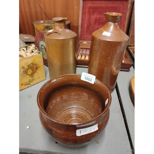 1002 - A collection of stoneware pottery items, two bottles and a bowl