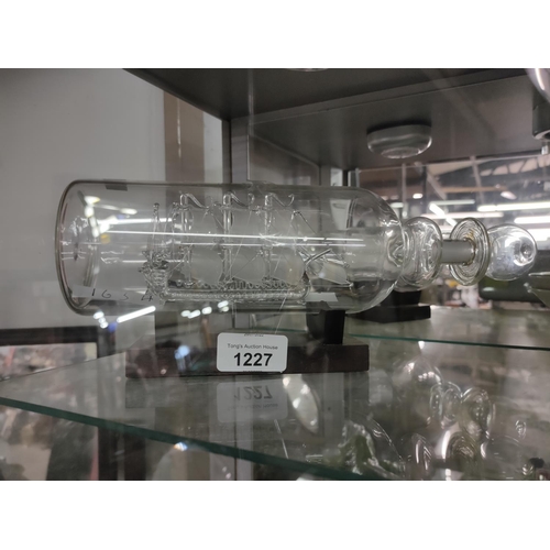 1227 - A glass ship in a bottle on stand