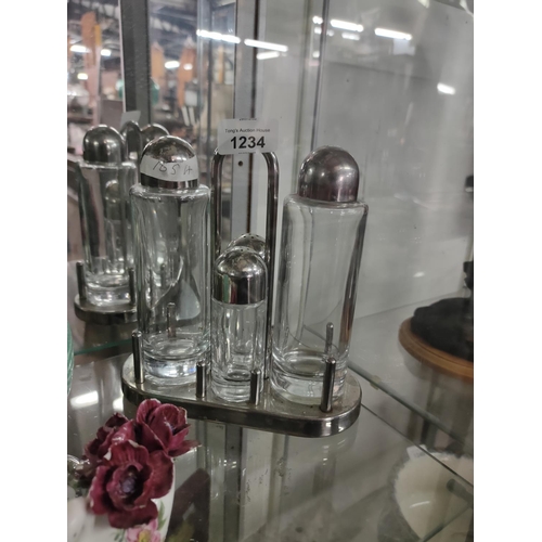 1234 - A chrome and glass cruet and oil set