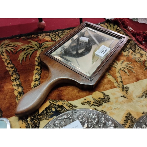 1293 - A nice quality hand held mirror in wooden surround