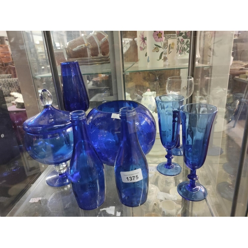 1375 - A collection of blue glass items including bottles, a vase and some glasses