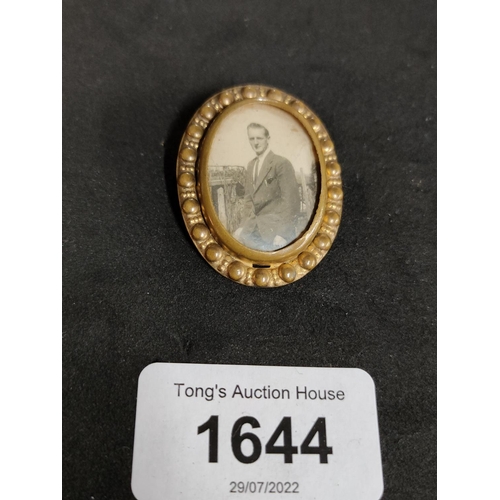 1644 - A vintage gold coloured brooch with a photograph of a young man