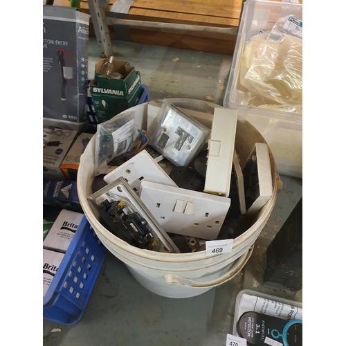 469 - A large tub full of socket covers and other electrical items