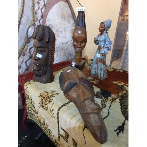 1345 - A collection of African carvings including masks and the beautiful earthenware figurine of a lady