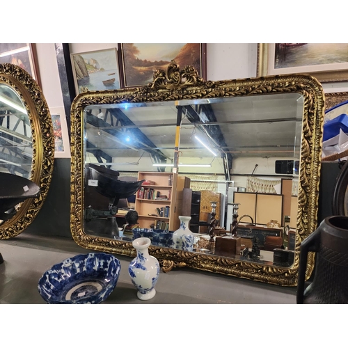 1045 - A beautiful large oblong mirror with heavily carved gold guilt frame and bevelled edge