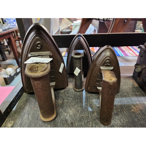 A collection of three heavy cast iron irons, Sylvesters patent No. 2, 3