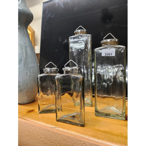 2061 - Collection of four triangular storage jars with metal lids