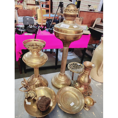 616 - A collection of brass ware, including oil lamps, a trivet and brass bowls.