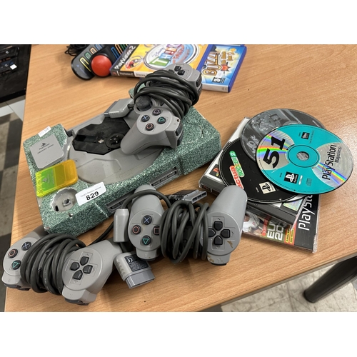 829 - PlayStation 1 console in need of attention along with three controllers, memory cards and game discs