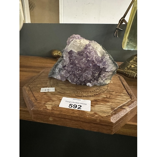592 - Amethyst/purple raw crystal on wooden plinth