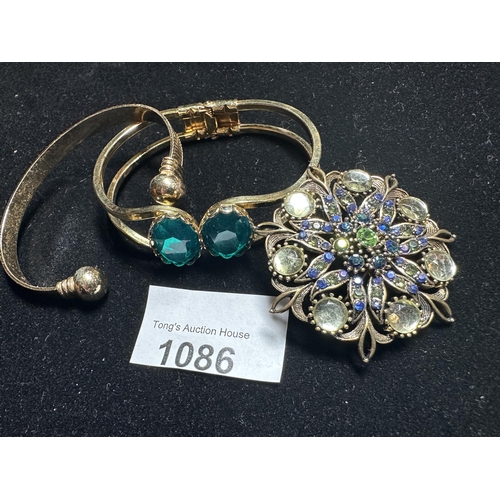 1086 - 2 x Gold toned bangles and multi stoned vintage brooch