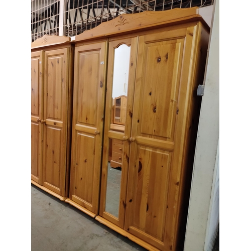 750 - 195cm H X 130cm W X 60cm D Three door pine wardrobe with mirror and shelf space,