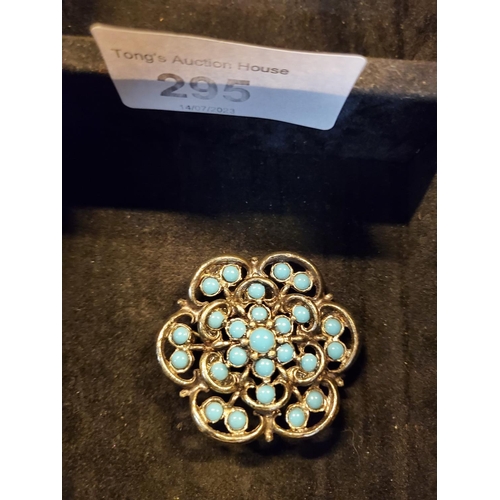 295 - Lovely white metal flower shaped brooch with turquoise coloured stone decoration