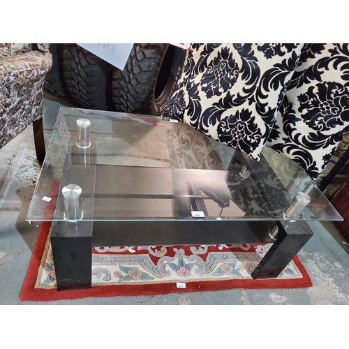 409 - Lovely and practical glass topped display unit in black and chrome. Measures approx 100 x 60 x 45cm