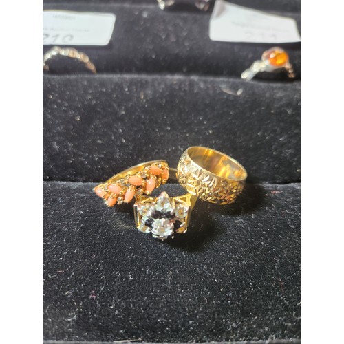 213 - Stunning 3 yellow metal rings, 2 with mixed stones. Coral coloured stone SIZE O, black coloured ston... 