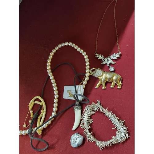 276 - A lovely selection of costume jewellery including an elegant elephant brooch and a faux tiger tooth ... 