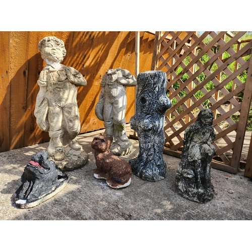 Collection of concrete garden ornaments including children and dogs.