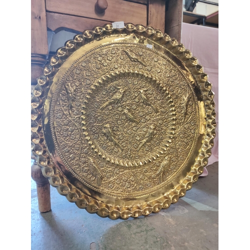 34 - A beautiful and large embossed brass tray with images of birds. Approx 2ft diameter