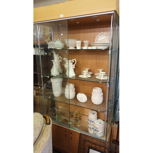 1110 - Large wood backed glass display unit with lights and storage cupboard. Measures approx 99cm x 198cm