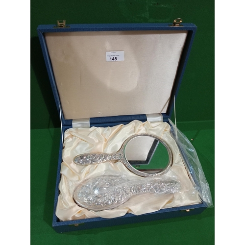145 - A boxed and hallmarked silver dressing table set of a hairbrush and hand mirror as new unopened cond... 