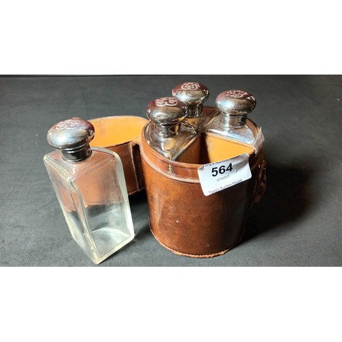 564 - 4 quarter circle bottles with silver tops in a round leather case, London 1909