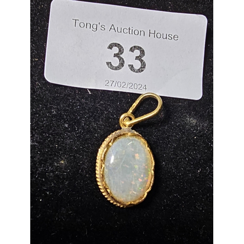 33 - 9ct gold pendant with opal stone centre