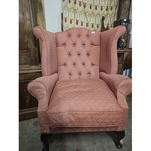 1000 - Pink upholstered winged armchair