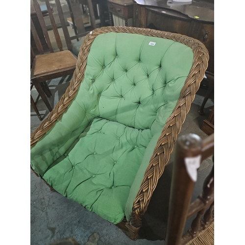 1024 - Large wicker armchair with padded green upholstery