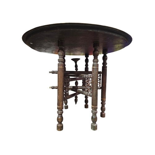 37 - Very large brass charger Indian influence on folding wooden turned legs 73cm in diameter