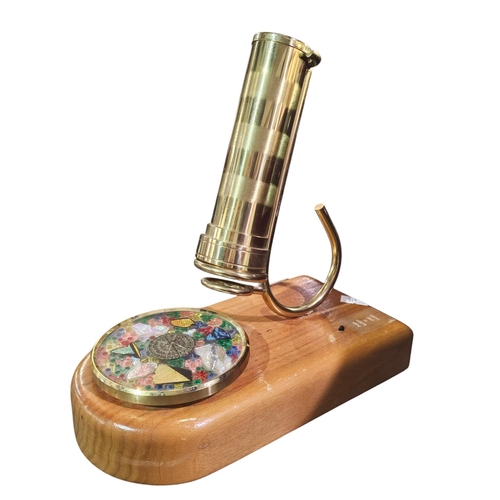 175 - Musical brass kaleidoscope mounted on a wooden plinth with a rotating glass wheel