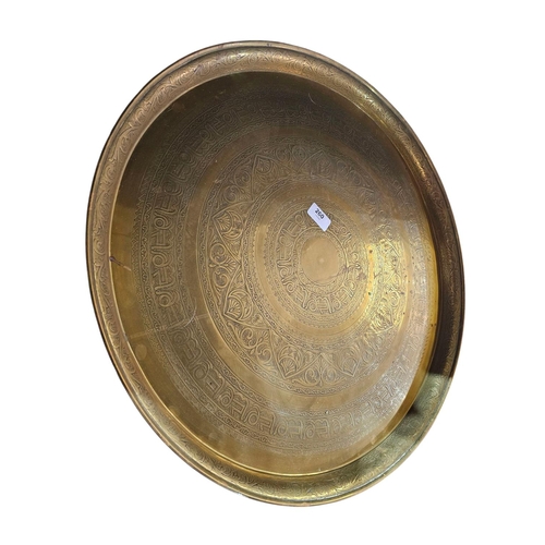 260 - Indian brass charger table top on wooden turned bass 57cm in diameter