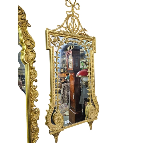 311 - A Classical style carved gilt wood wall mirror, the shaped retangular plate surmounted by a ribbon t... 