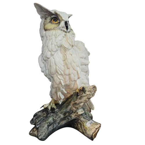 332 - An earthenware model of a Tawny Owl, poised perched upon a branch, approx 60cm tall