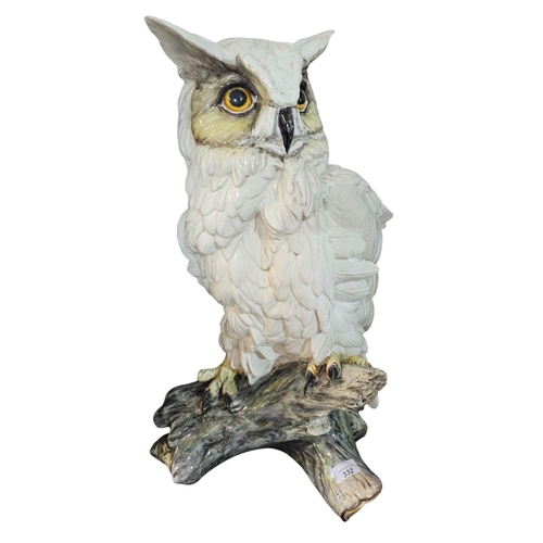 332 - An earthenware model of a Tawny Owl, poised perched upon a branch, approx 60cm tall