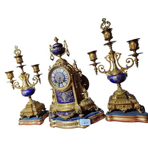 411 - A late 19th century French gilt bronze clock garnature, with ground sèvres panel decoration the circ... 