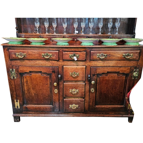 453 - An early 18th century oak dresser, with boarded back above a moulded cornice, and shaped under friez... 