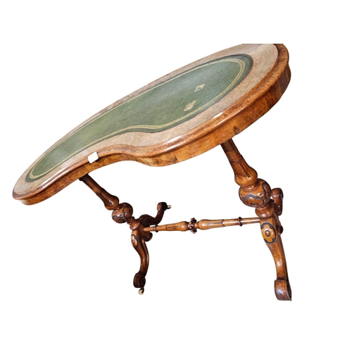 694 - A Victorian figured walnut kidney shaped writing table with green leather insert raised on turned an... 