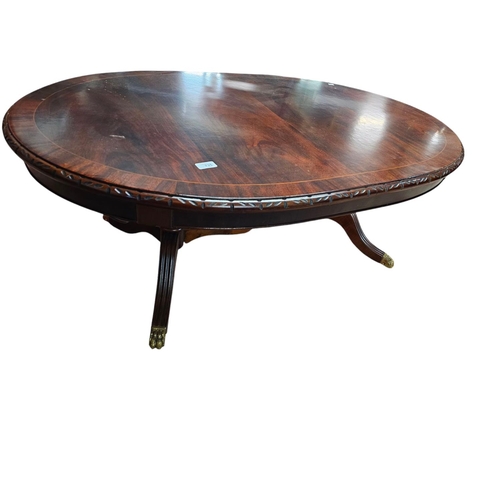 735 - Low mahogany long pedestal table with brass claw feet and central stretcher