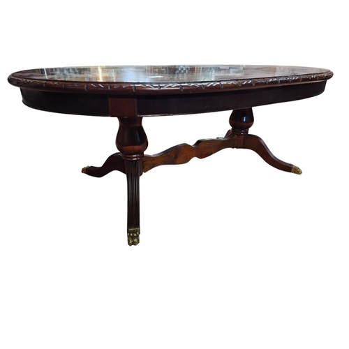 735 - Low mahogany long pedestal table with brass claw feet and central stretcher