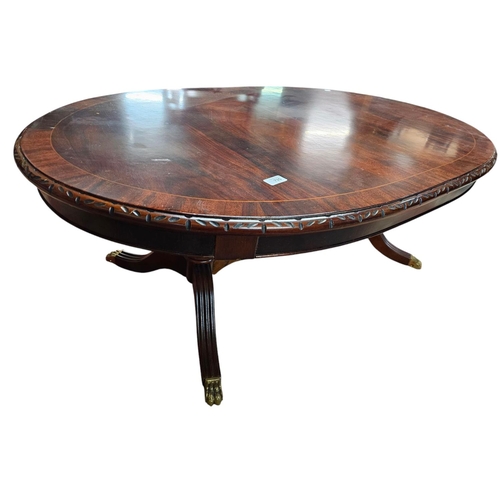 735 - Low mahogany long pedestal table with brass claw feet and central stretcher