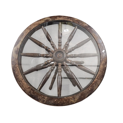 744 - Solid wagon wheel base glass topped table