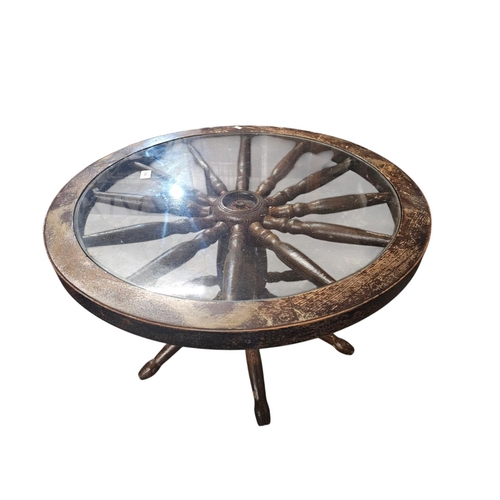 744 - Solid wagon wheel base glass topped table